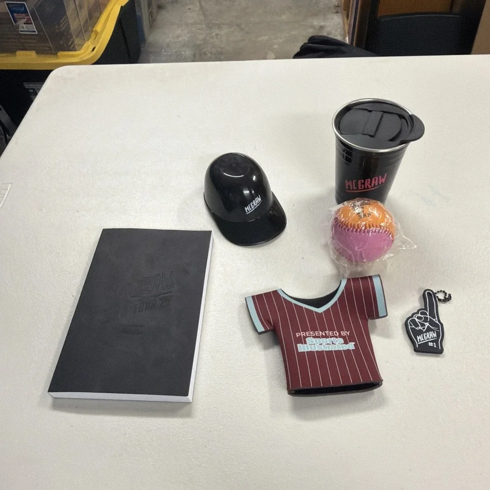 collection of McGraw-branded tour merchandise, including a clear tote bag 2024